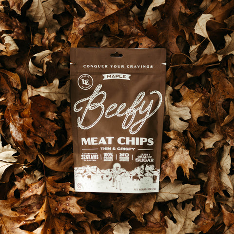 Bag of Maple Beefy Meat Chips on a bed of autumn leaves